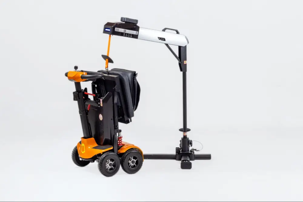 Folded orange mobility scooter attached to a portable car lift on a white background