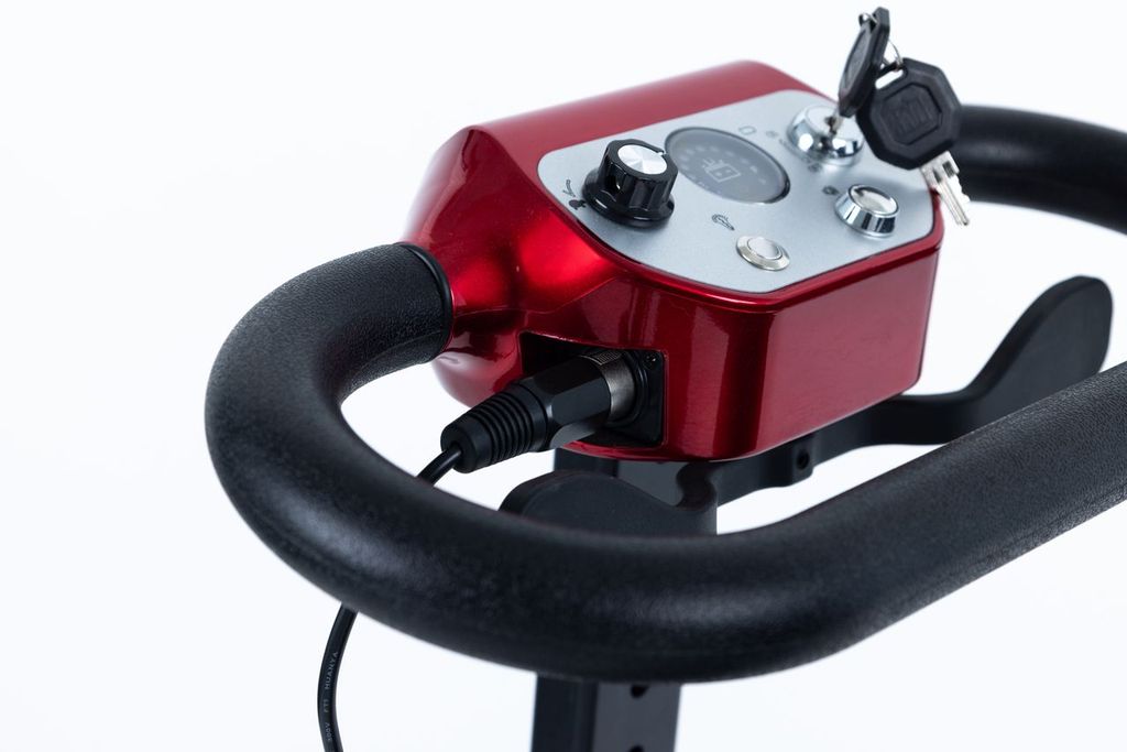 Mobility scooter tiller control panel with red housing and key ignition.