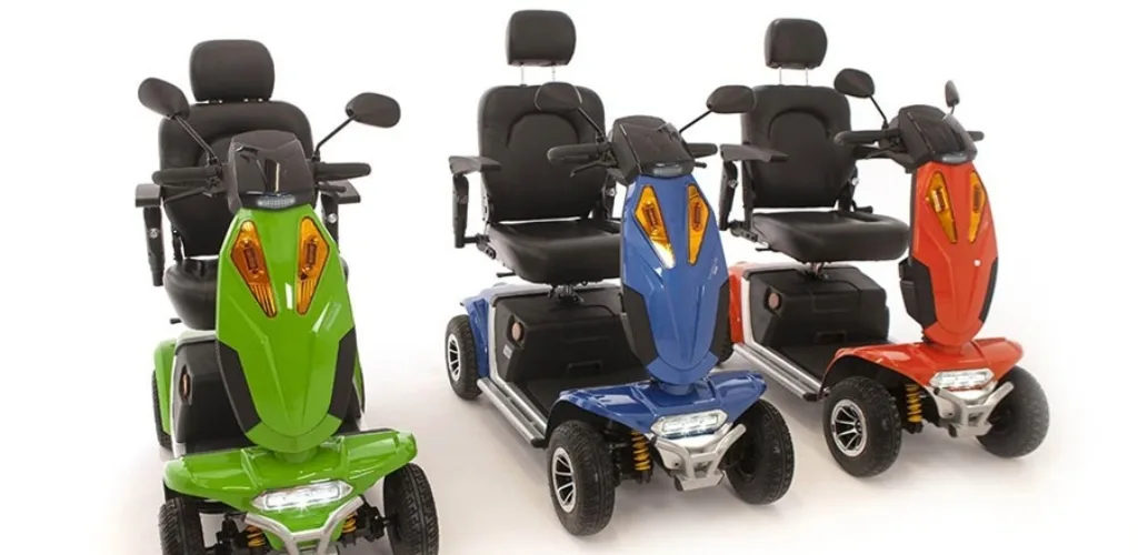Three Vogue Sport mobility scooters in green blue and red