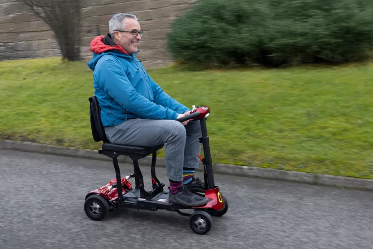 Gentleman riding Monarch Red Genie mobility scooter