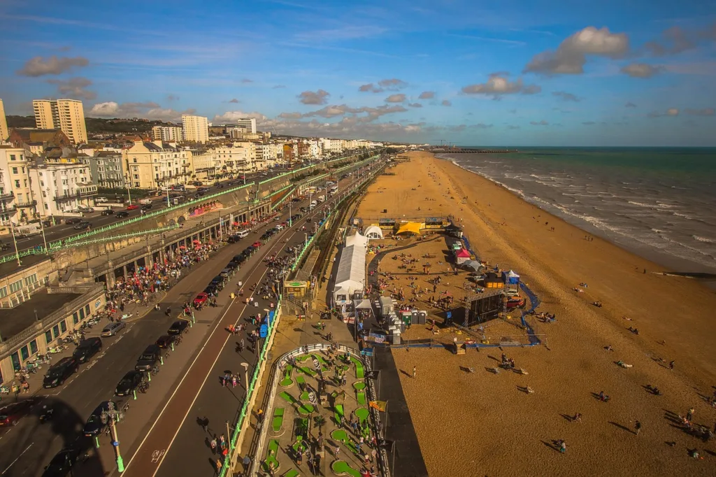 A birds eye view of the sea, beach, promenade and buildings along Brighton seafront