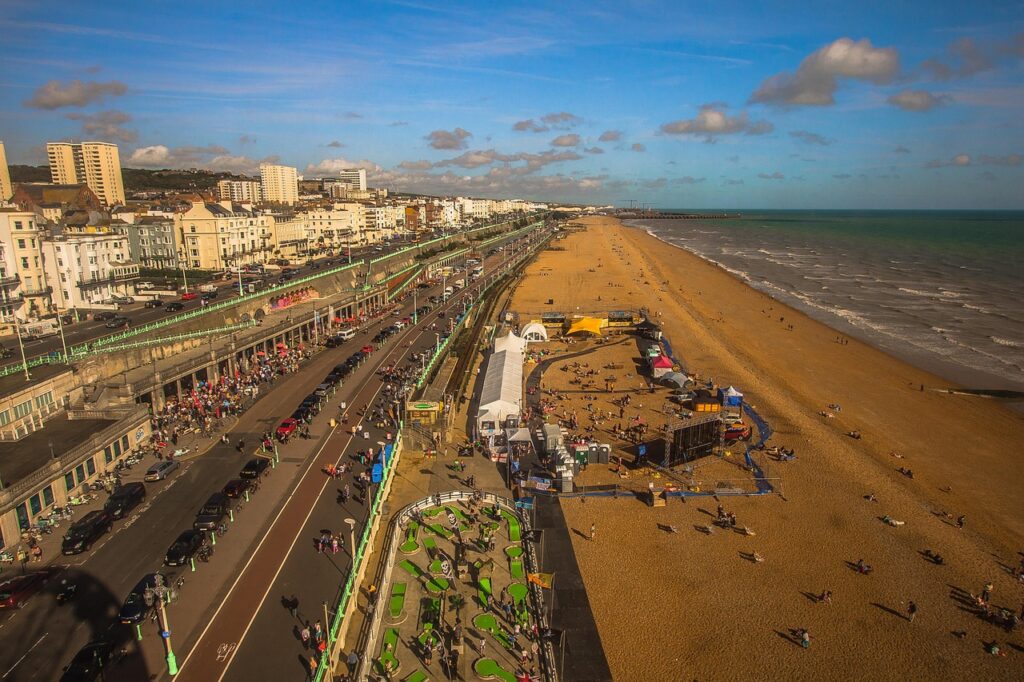 A birds eye view of the sea, beach, promenade and buildings along Brighton seafront