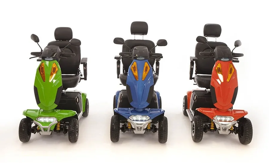 Three Vogue mobility scooters in green, blue and red