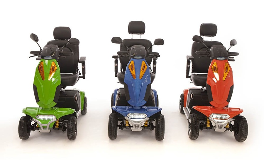 Three Vogue mobility scooters in green, blue and red