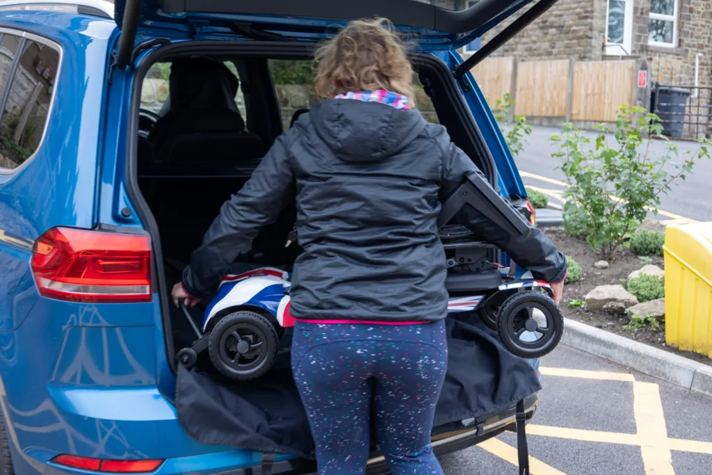 Katie Toft loading the Genie Ultralight mobility scooter into the boot of her car