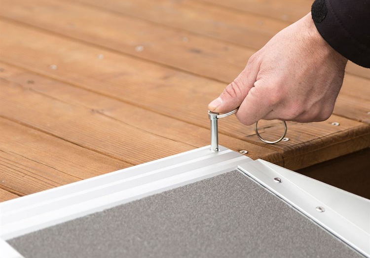 A hand securing a folding ramp in place