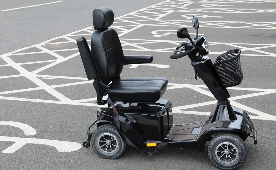 A grey mobility scooter parked in a disabled bay